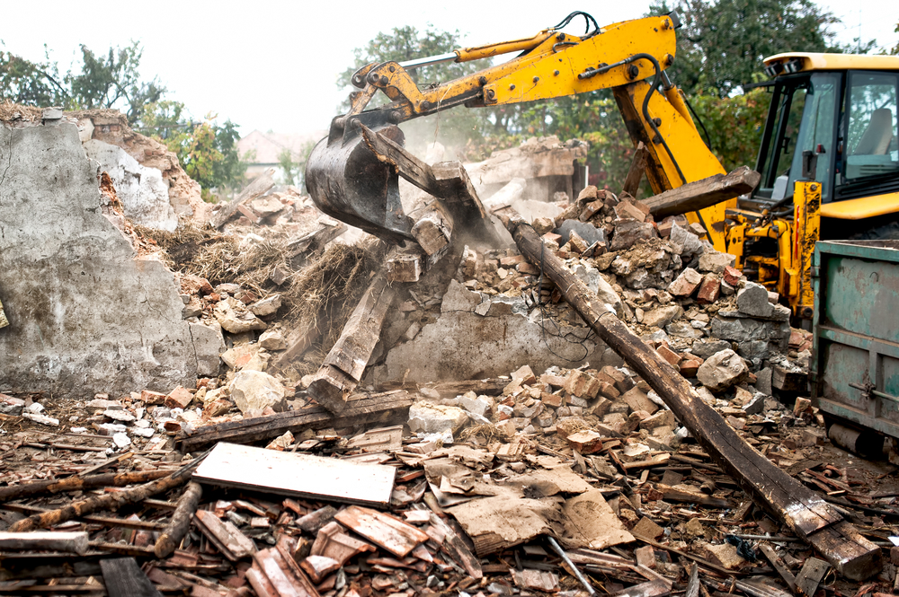 Industrial,excavator,and,bulldozer,loading,debris,and,demolition,concrete,walls