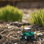 Toy,tractor,on,green,grass,background,.,spring,sowing,works